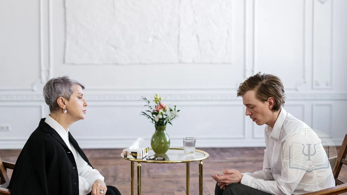 Psicóloga escuchando de forma reflexiva a un paciente durante una entrevista motivacional en una consulta luminosa